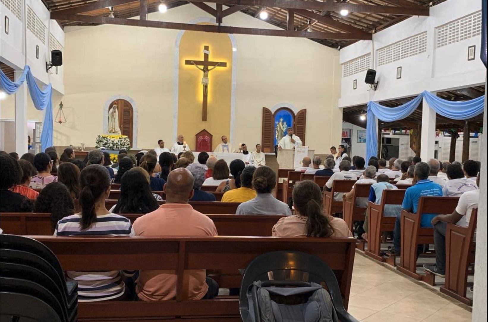 Interior da Paróquia Coração Imaculado de Maria com celebrantes e fiéis
